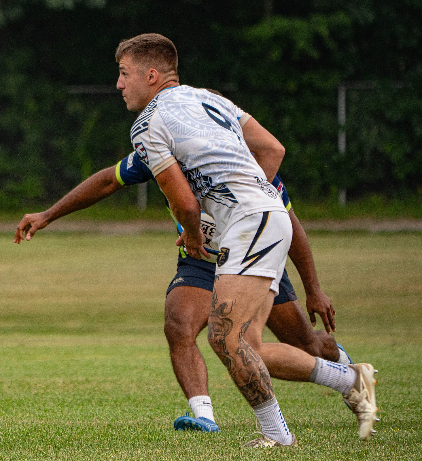 Scrum-half shields the ball away from a defender — men's premier